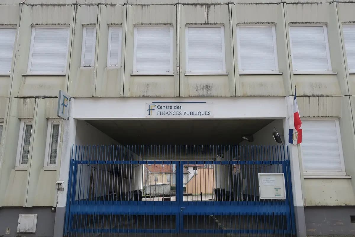 Fachada de un centro de finanzas públicas con la bandera francesa, en Remiremont, en los Vosgos