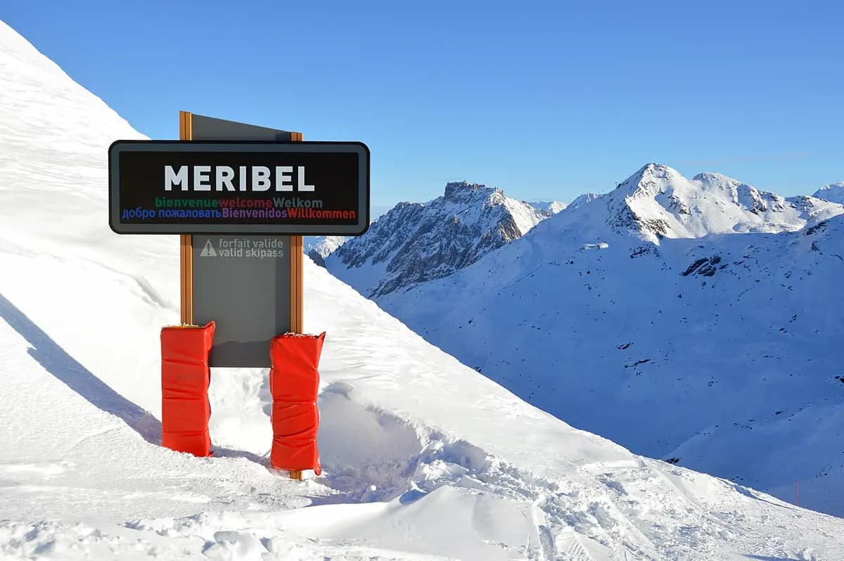 Cartello di benvenuto di Méribel in sei lingue in un paesaggio montano innevato